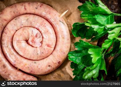 Round raw sausage on paper. High quality photo. Round raw sausage on paper.