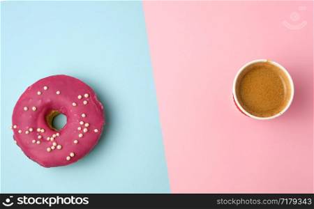 round red glazed donut and paper cup with coffee on a colored background, top view