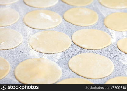 round shape of the dough with flour on the table