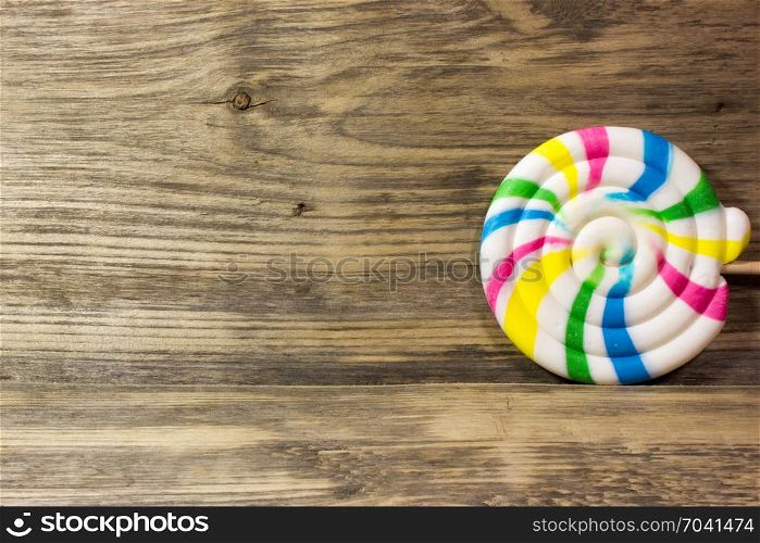 Round spiral color candy on wooden background.