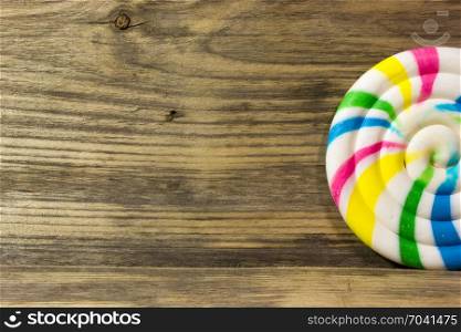 Round spiral color candy on wooden background.