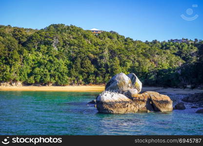 Round stone boulder and sand bay in Abel Tasman National Park. New Zealand. Round stone boulder in Abel Tasman National Park, New Zealand