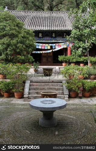 Round table in the inner yard of buddhist temple in Black Dragon park in Lijiang, China