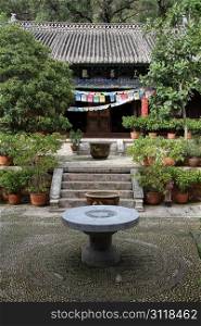 Round table in the inner yard of buddhist temple in Black Dragon park in Lijiang, China