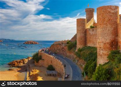 Round tower with the flag of Catalonia in fortress, Gran Platja beach and Badia de Tossa bay in Tossa de Mar on Costa Brava, Catalunya, Spain