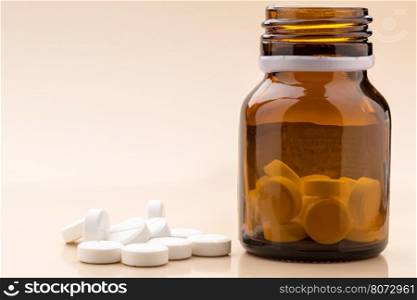 Round white pills and glass pill bottle. Heap of round red pills and glass pill bottle