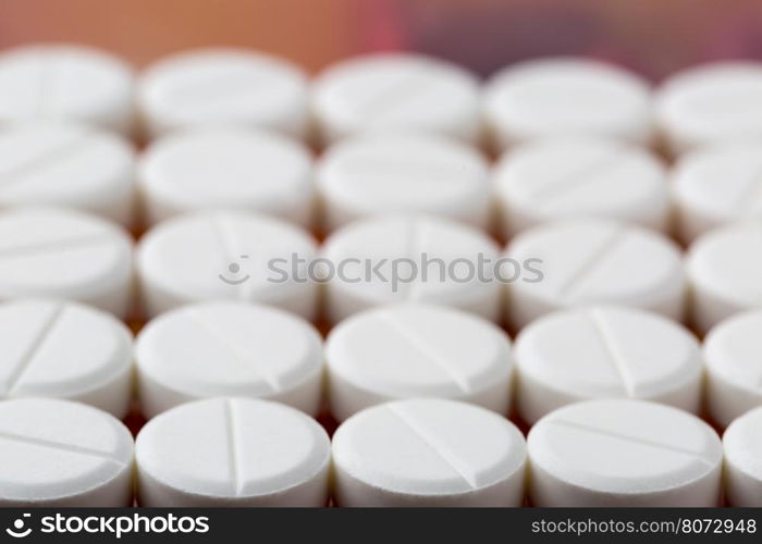 Round white pills. Heap of round white pills on colorful background