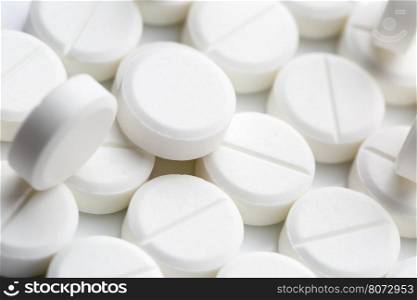 Round white pills. Heap of round white pills on white background