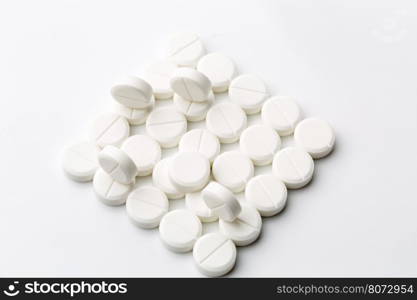 Round white pills. Heap of round white pills on white background