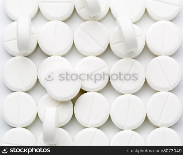 Round white pills. Heap of round white pills on white background