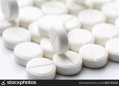 Round white pills. Heap of round white pills on white background