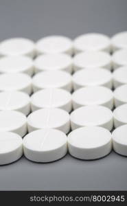 Round white pills . Round white pills on a gray background