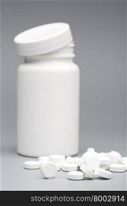 Round white tablet with the pill bottle. Round white tablet with the pill bottle on a gray background