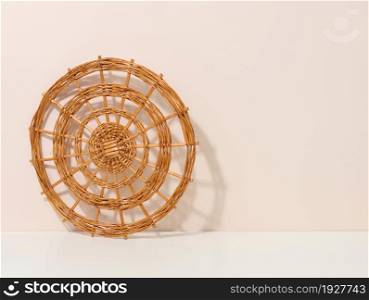 round wicker kitchen utensil rack on white table, copy space