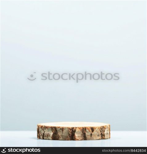 Round wooden saw cut cylinder shape on blue background. Minimal box and geometric podium. Empty showcase for eco cosmetic product presentation