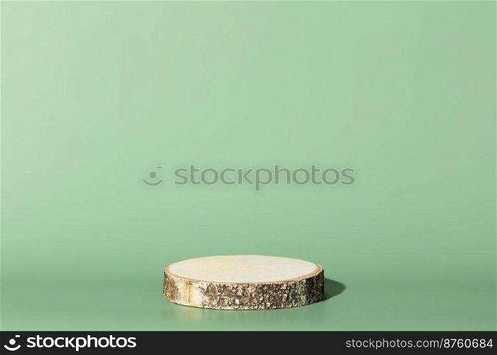 Round wooden saw cut cylinder shape on green background abstract background. Minimal box and geometric podium. Scene with geometrical forms. Empty showcase for eco cosmetic product presentation