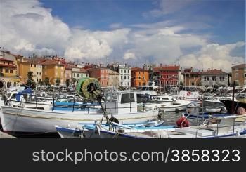 Rovinj city, Croatia, boats parked in the port, houses by the sea, timelapsed clouds