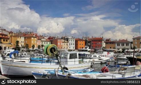 Rovinj city, Croatia, boats parked in the port, houses by the sea, timelapsed clouds