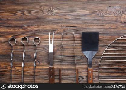 row barbecue utensils wooden table