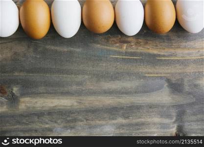 row brown white eggs wooden background
