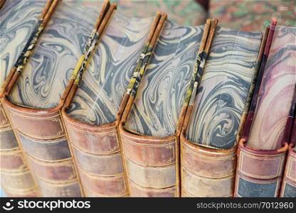 Row of antique books in a leather hardcover close-up, top view