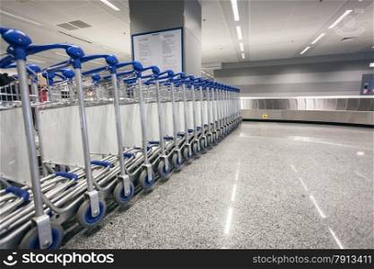 Row of baggage trolleys at arrival terminal in airport