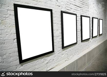row of black frames on white brick wall