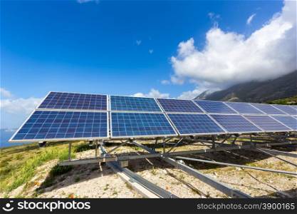Row of blue solar panels on mountain in greece with blue sky