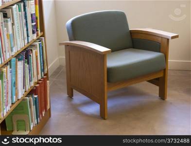 Row of books on a shelf next to seating area in the library