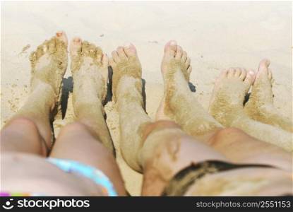 Row of children&acute;s feet on a beach covered in sand
