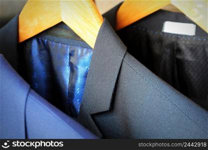 Row of classic men&rsquo;s suits hanging for sale.. Row of classic men&rsquo;s suits hanging for sale