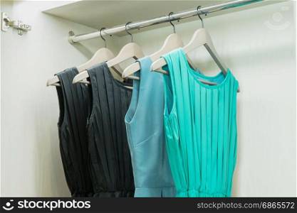 row of colorful dress hanging on coat hanger in white wardrobe