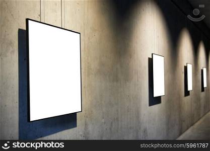 Row of empty black frames on concrete wall in the gallery isolated on white