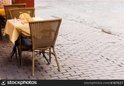 Row of empty restaurant tables in cobbled street in Brussels