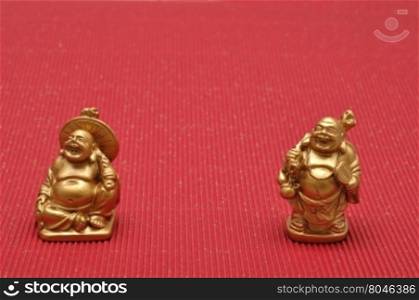 Row of Figurines of laughing and cheerful golden Buddhas