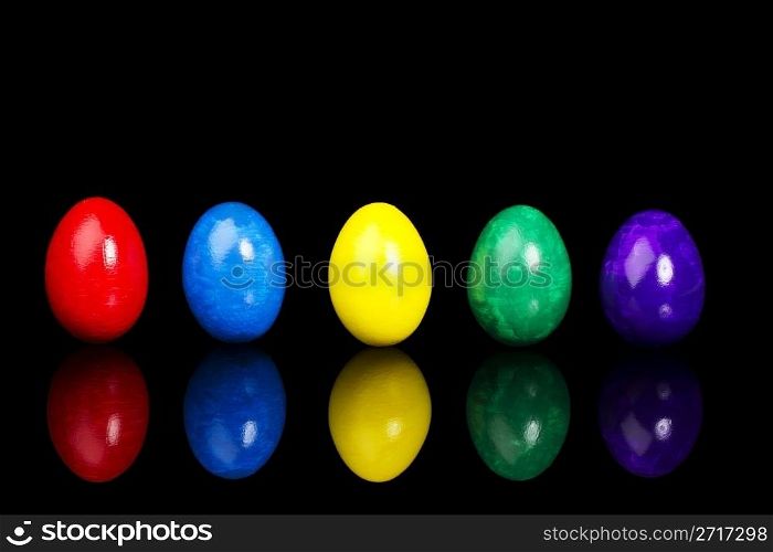 row of five easter eggs. row of five colorful easter eggs on black background with reflection