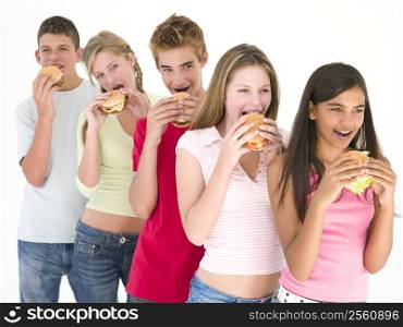 Row of five friends eating hamburgers