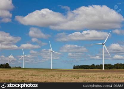 Row of Four Green Energy Wind Turbines In a Field