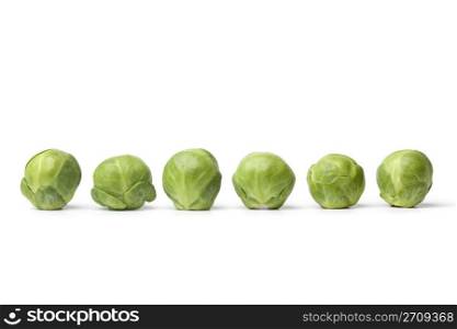 Row of fresh Brussel sprouts on white background