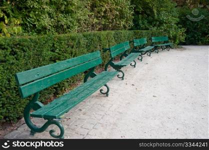 Row of green benches in Bruges park