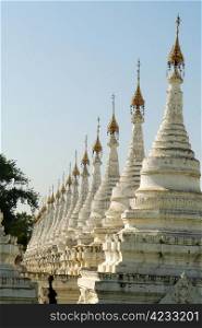 Row of historic white buddhist stupa in Myanmar