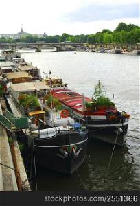 Row of houseboats docked on river Seine in Paris, France.