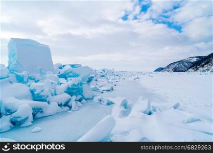 Row of ice blocks and the mountain covering with snow at lake Baikal in Russia in the winter