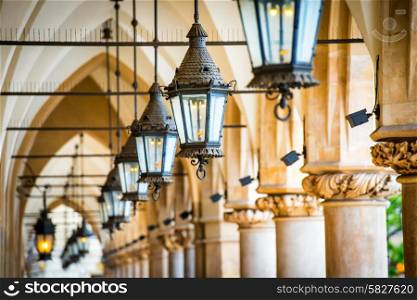Row of lamps. Passage in gothic hall with columns