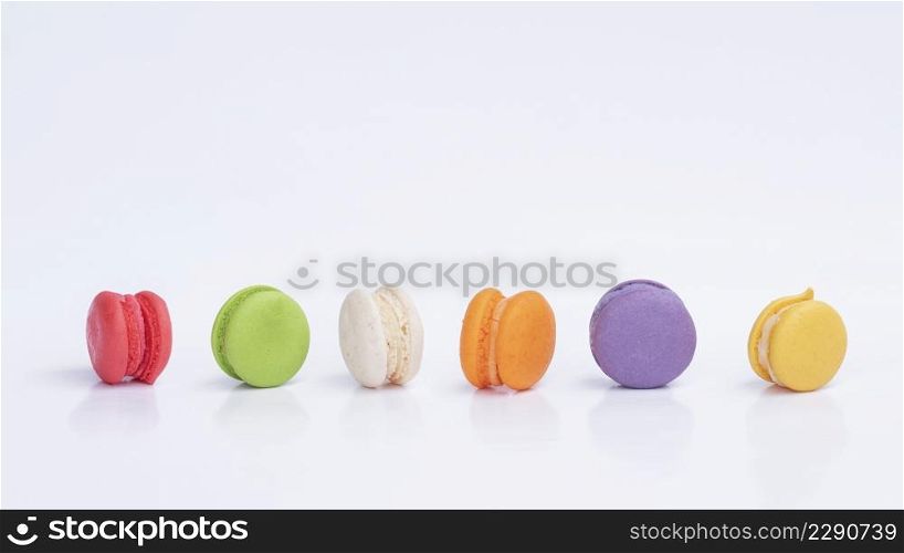 Row of mini colorful macarons on white background