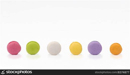 Row of mini colorful various taste macarons on white background