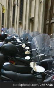 Row of motorcycles beside building, Italy.