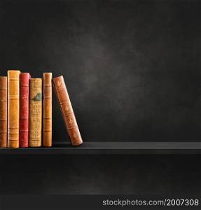 Row of old books on black shelf. Square scene background. Row of old books on black shelf. Square background