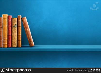 Row of old books on blue shelf. Horizontal background scene. Row of old books on blue shelf. Horizontal background