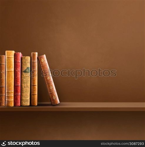 Row of old books on Brown shelf. Square scene background. Row of old books on brown shelf. Square background